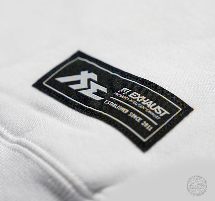 Fi EXHAUST black and white authenticity patch a a white hoodie's lower hip.