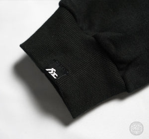 Fi EXHAUST authenticity patch on a black hoodie's cuff.